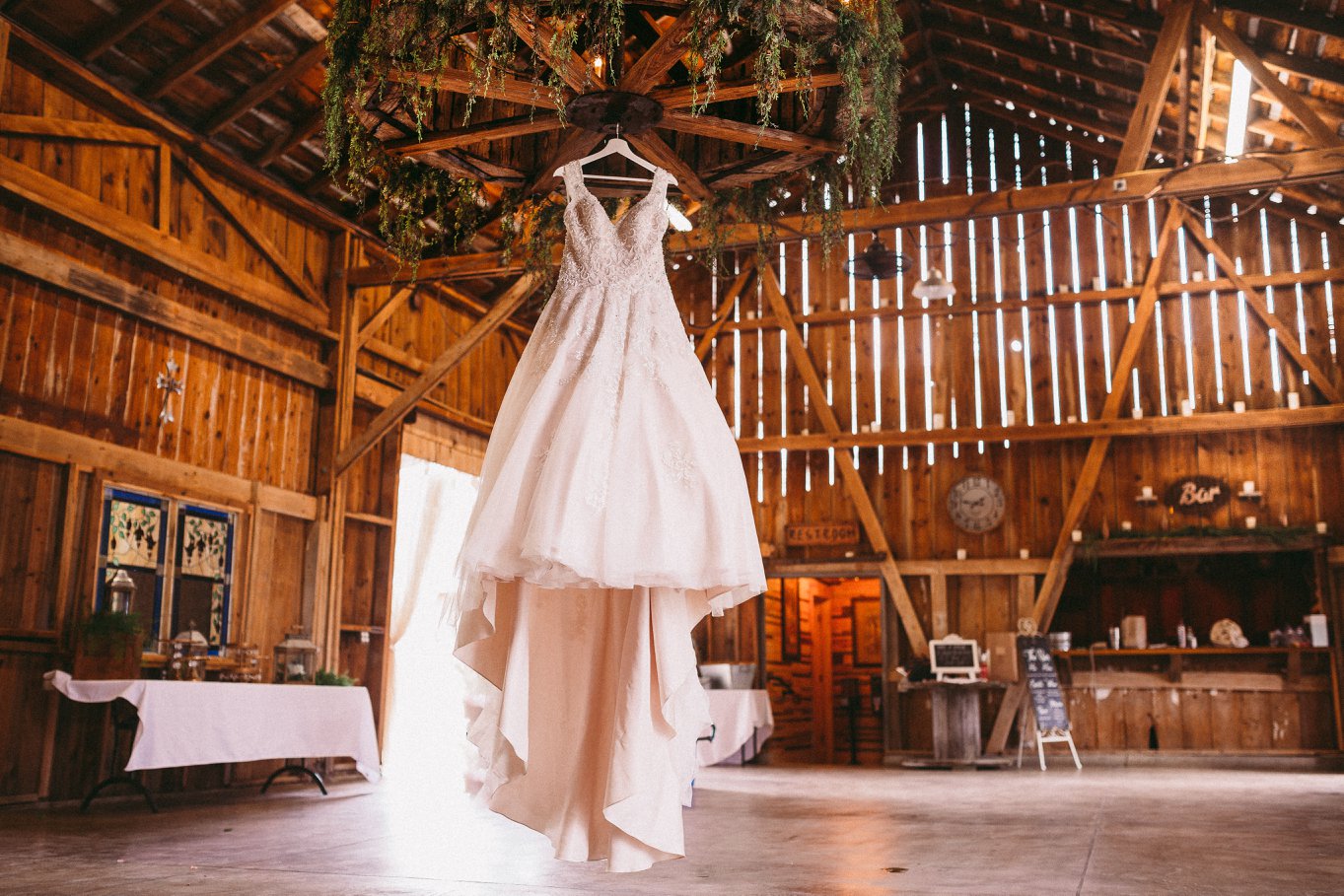 bridal gown hanging from venue chandelier