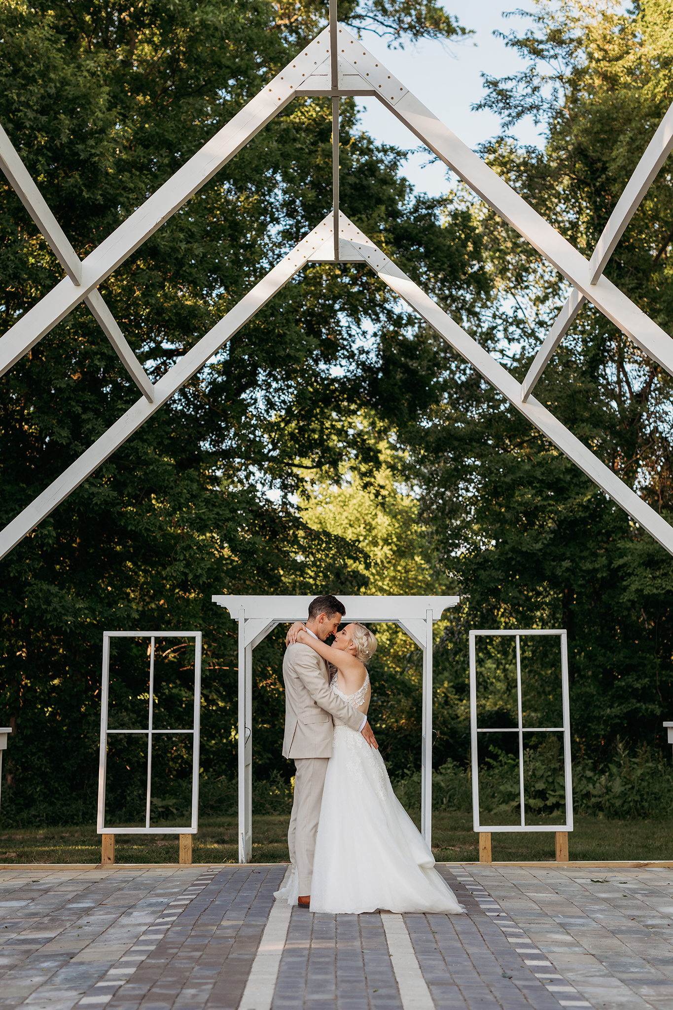 groom and bride kissing under pergola