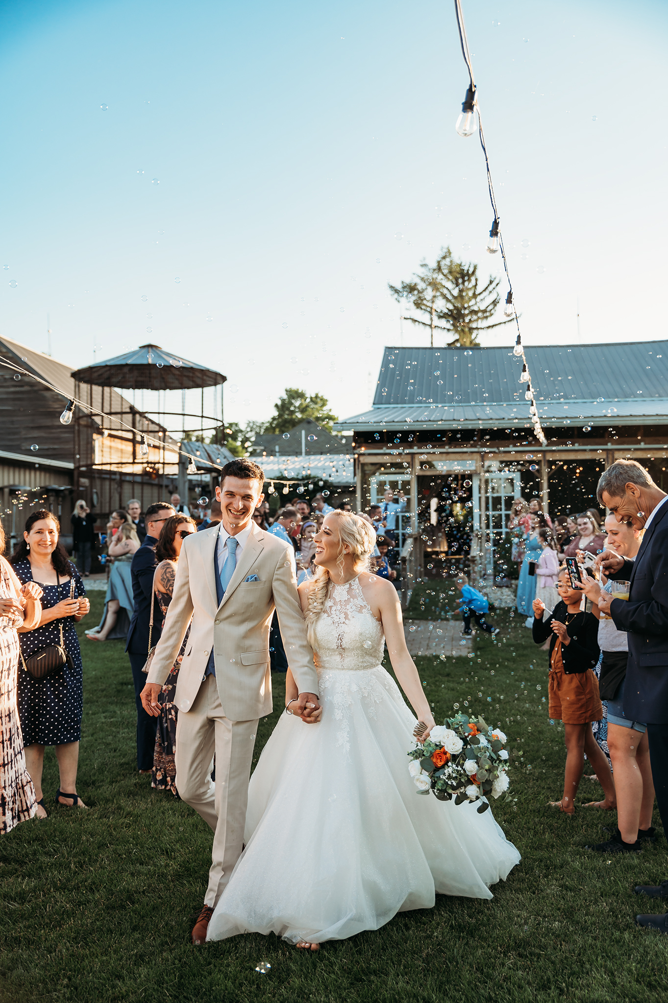 bride and groom entering outdoor wedding reception