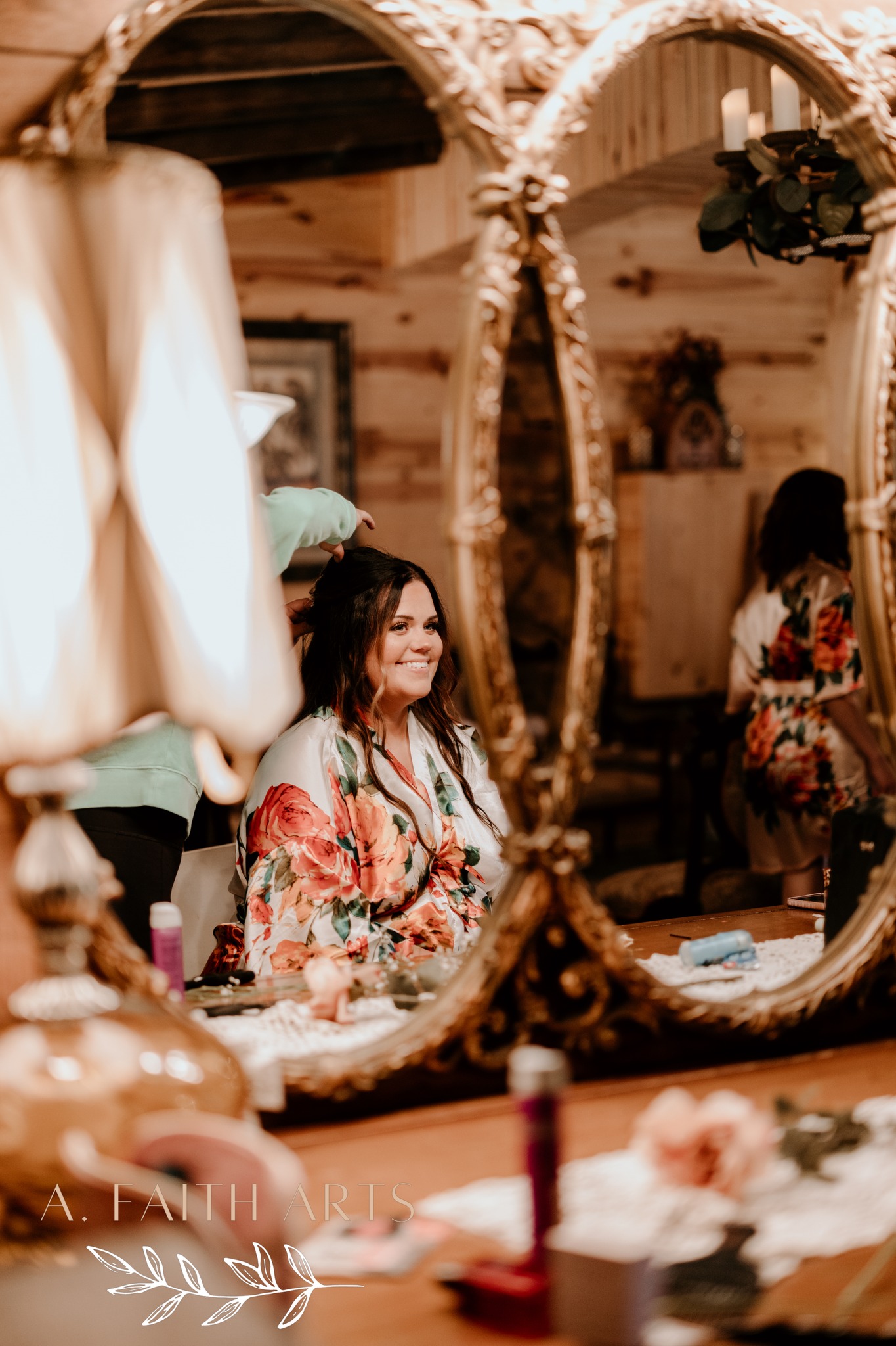 bride looking at herself in mirror while having hair styled