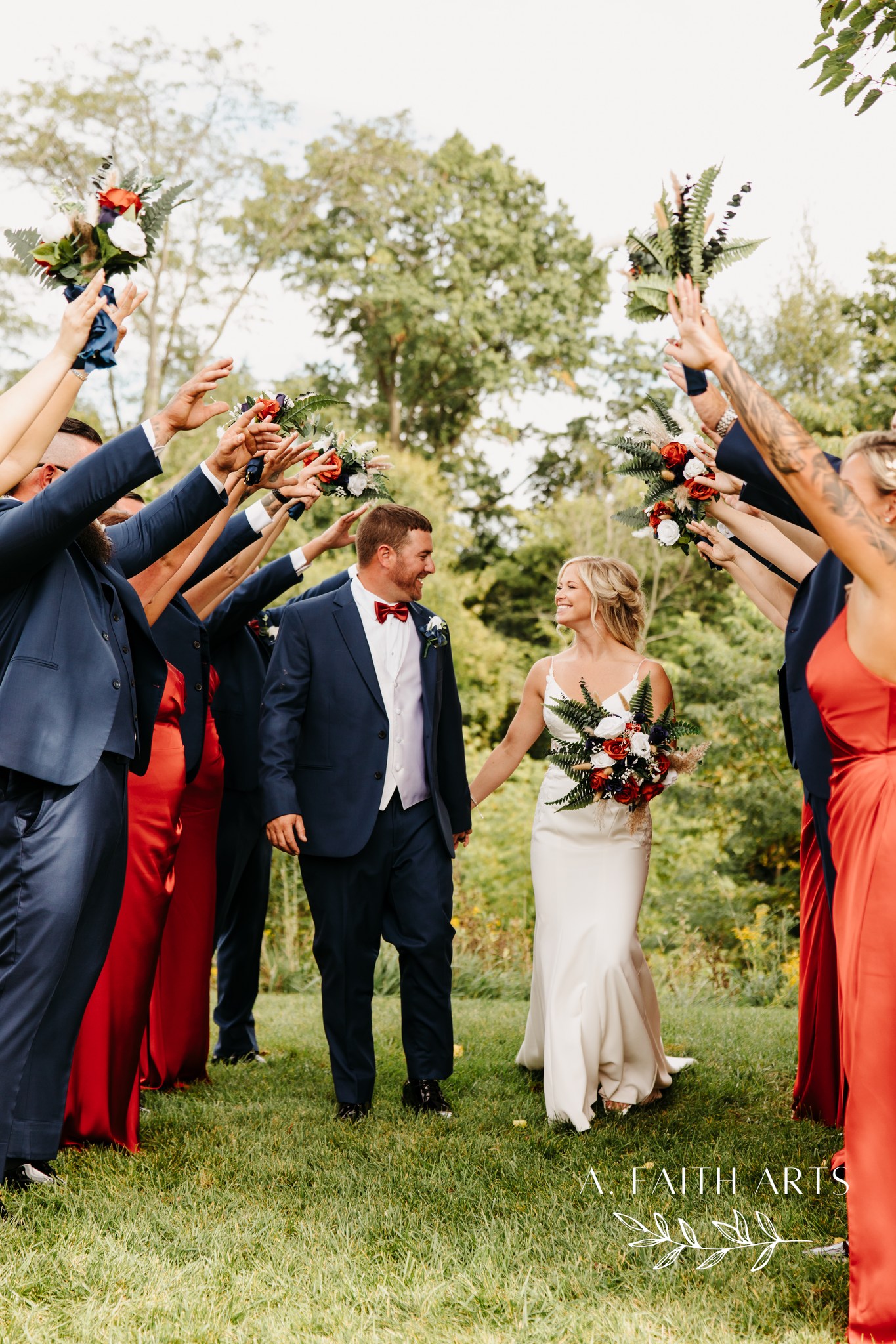 bride and groom walking through wedding party's arms