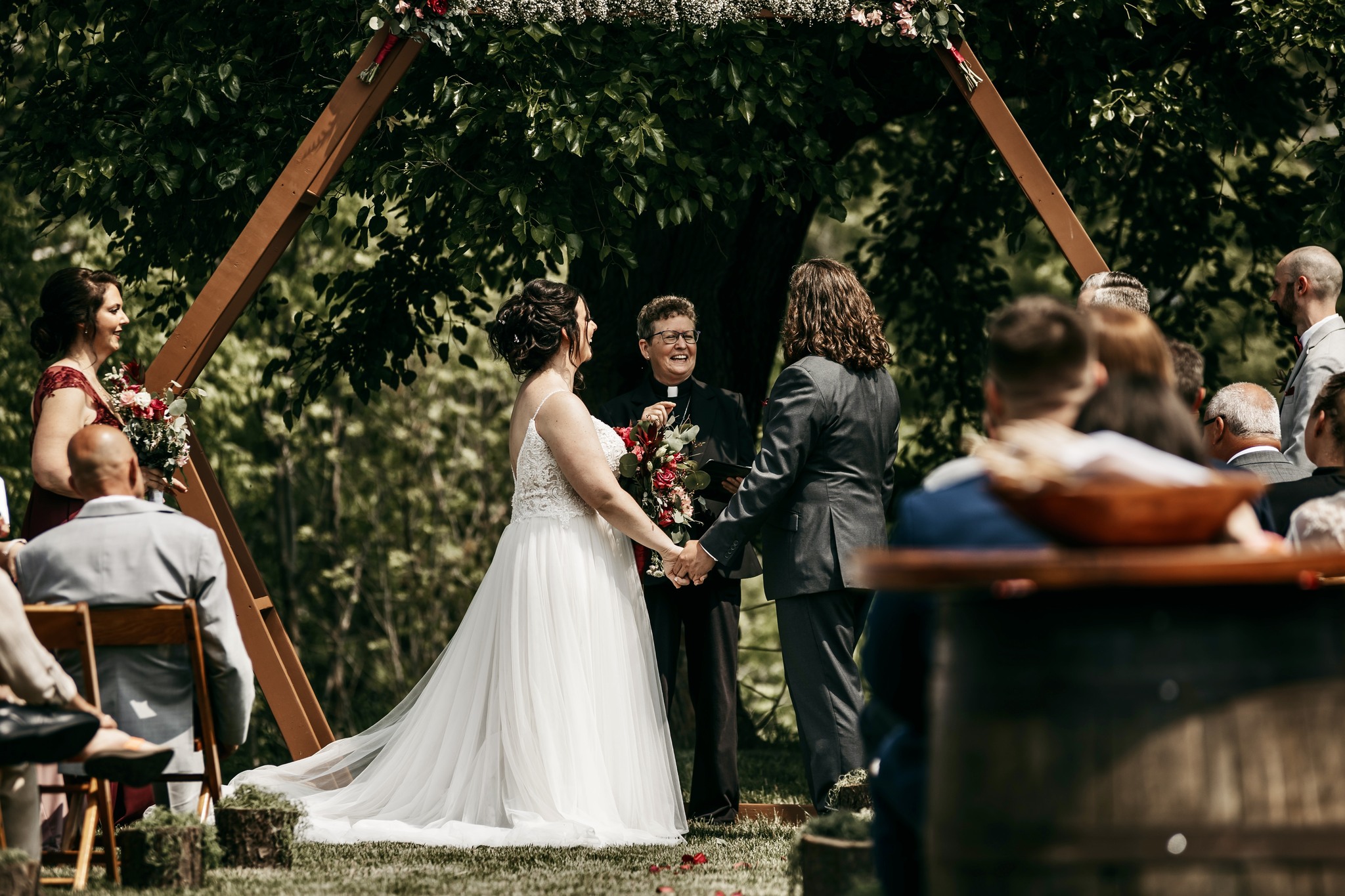 bride and groom holding hands during outdoor wedding ceremony