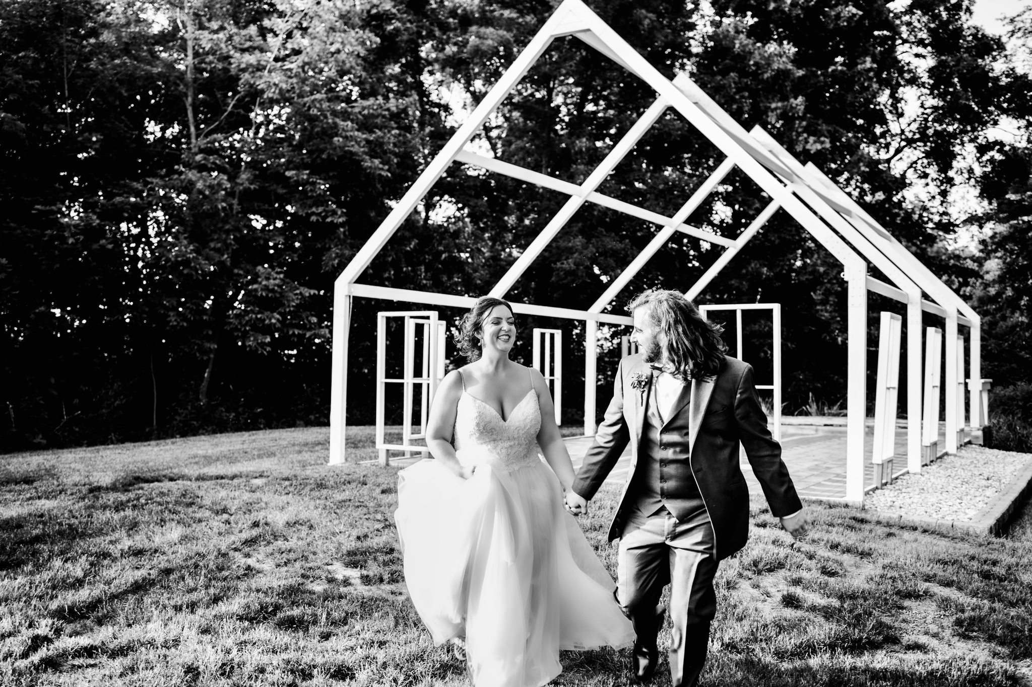 bride and groom under the palm tree barn pergola