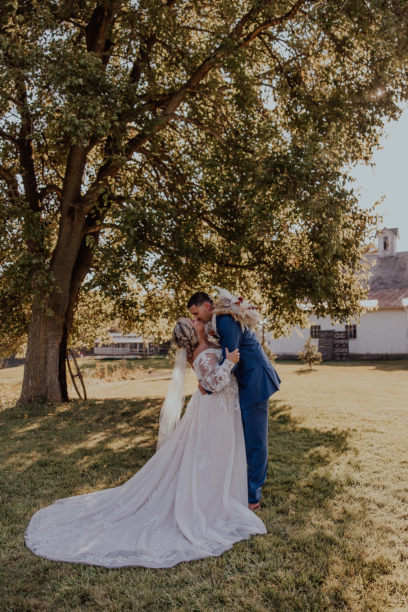 bride and groom kissing under tree