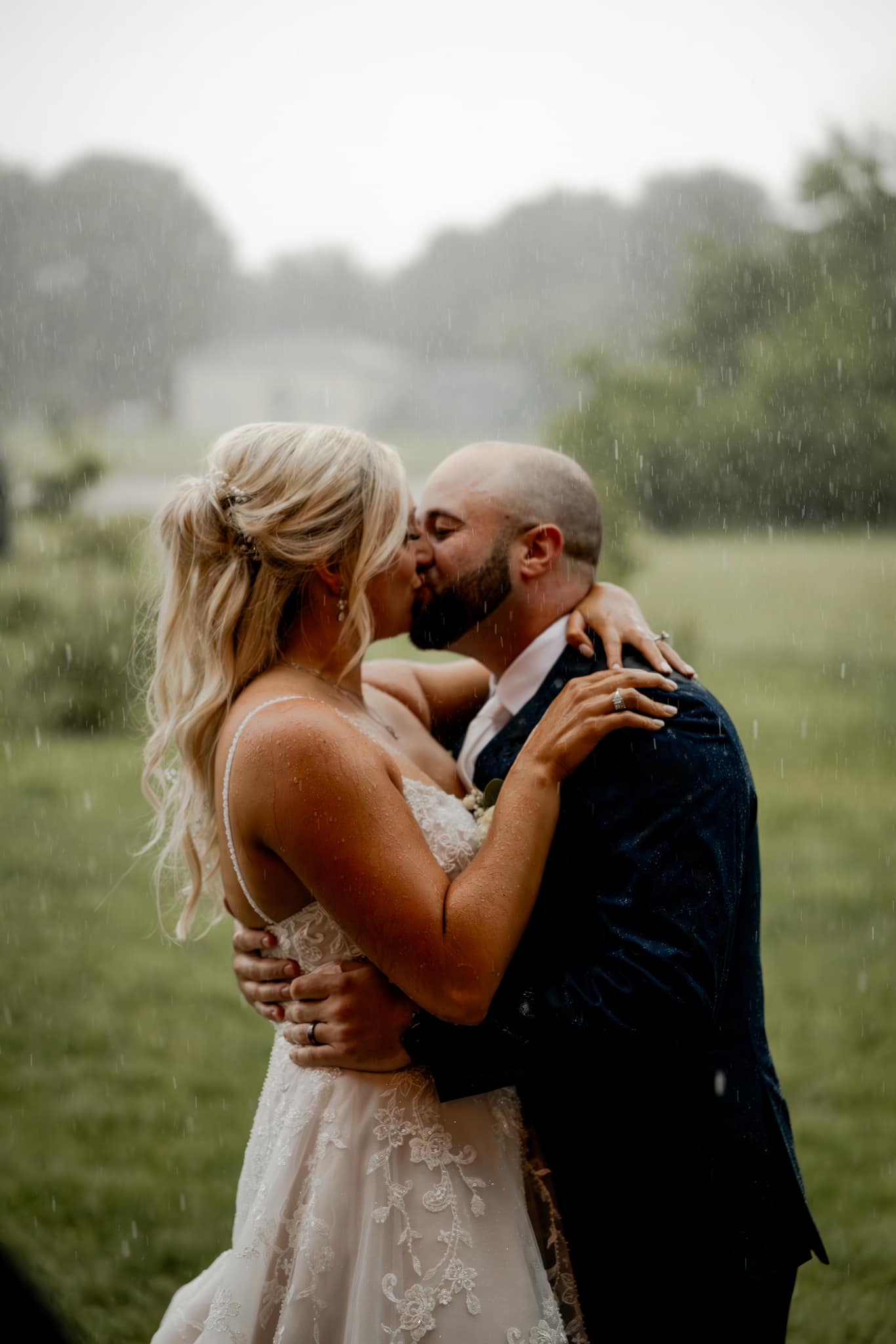 bride and groom kissing in the rain