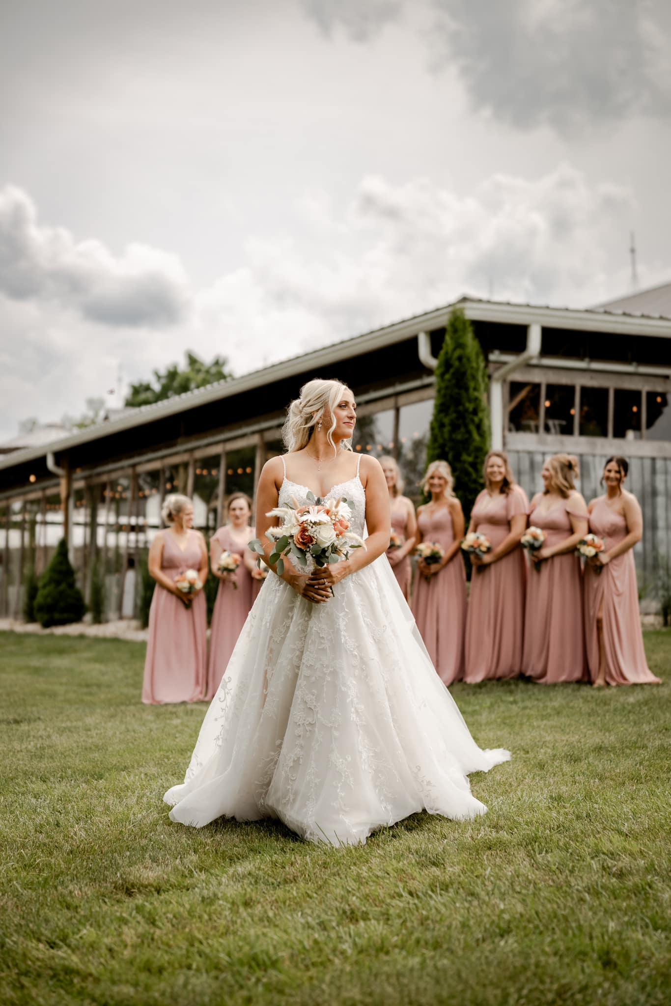 bride posing with bridesmaids behind her