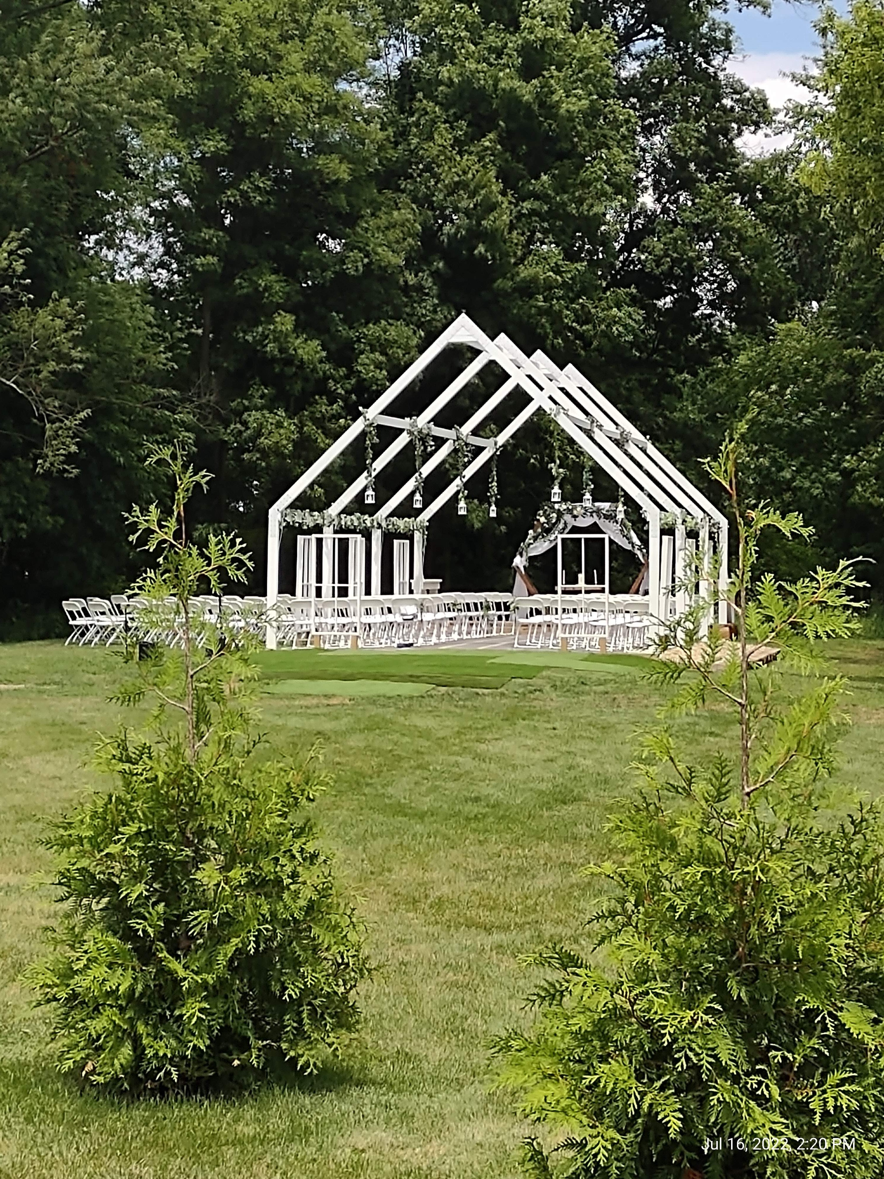 outdoor wedding ceremony under large white pergola